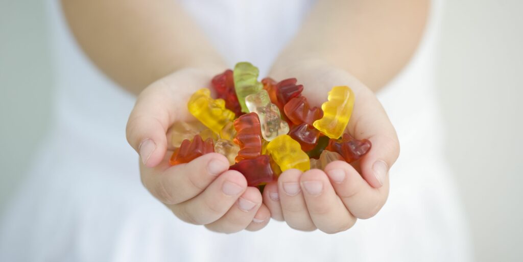 little-girl-with-a-handful-of-gummy-bears-royalty-free-image-1572269588